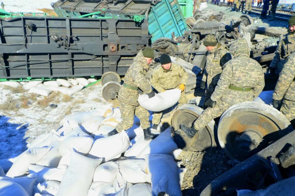 Военнослужащие помогают железнодорожникам разбирать мешки с пшеницей после аварии с поездом