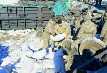 Военнослужащие помогают железнодорожникам разбирать мешки с пшеницей после аварии с поездом