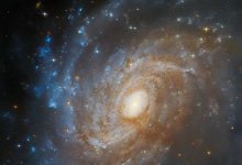 Телескоп "Хаббл" показал спиральную галактику, скрытую в темном облаке